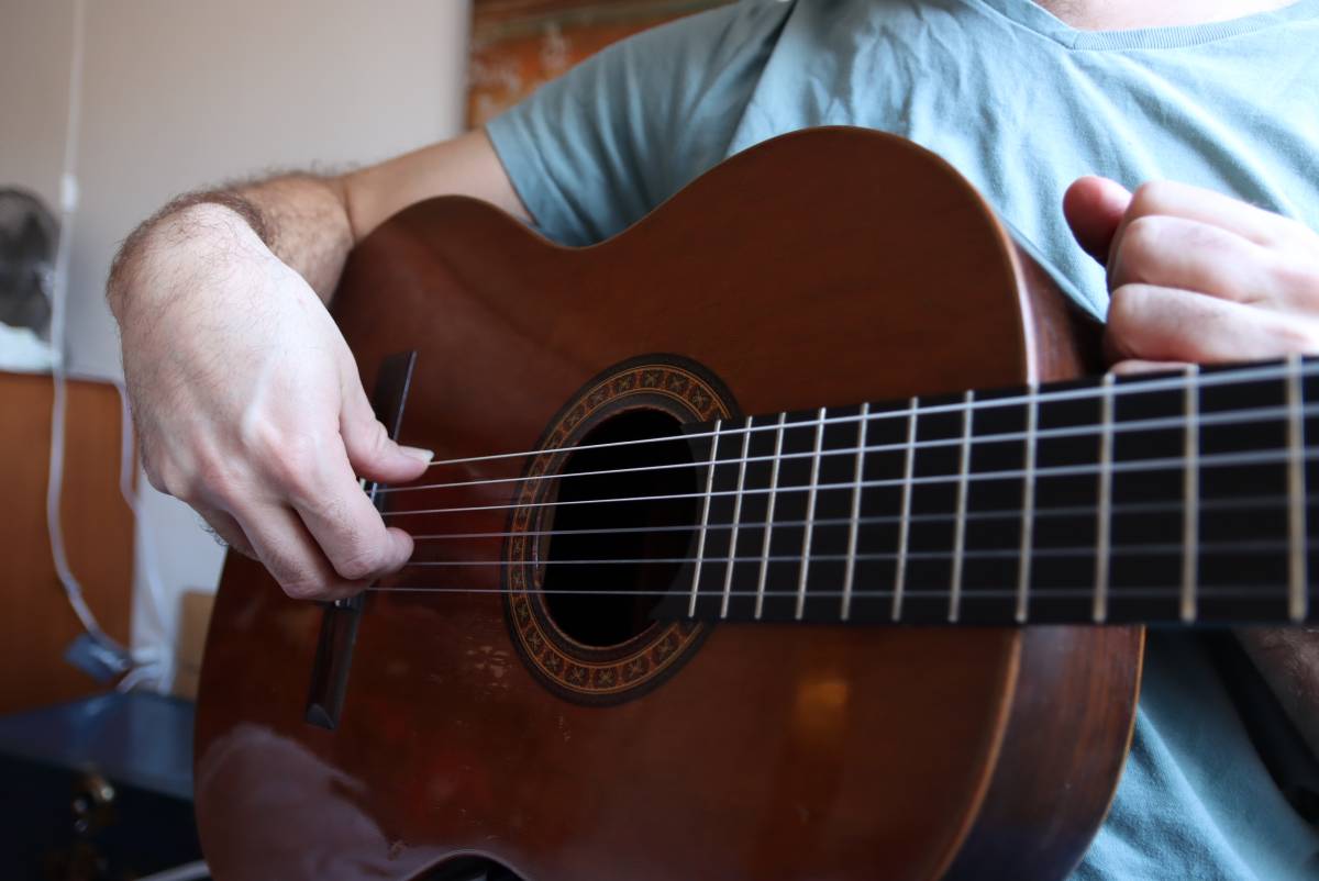 Right hand wrist position doing rest stroke on a bass guitar