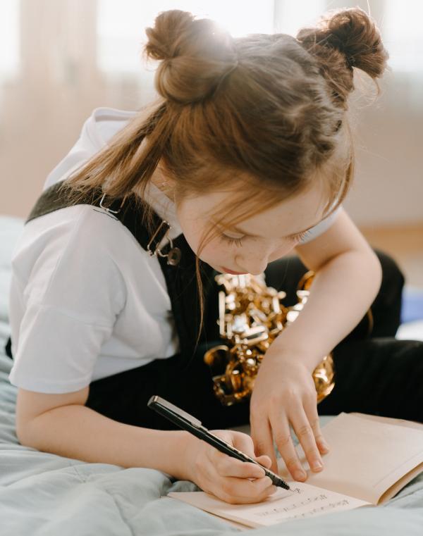 girl writing music in a journal