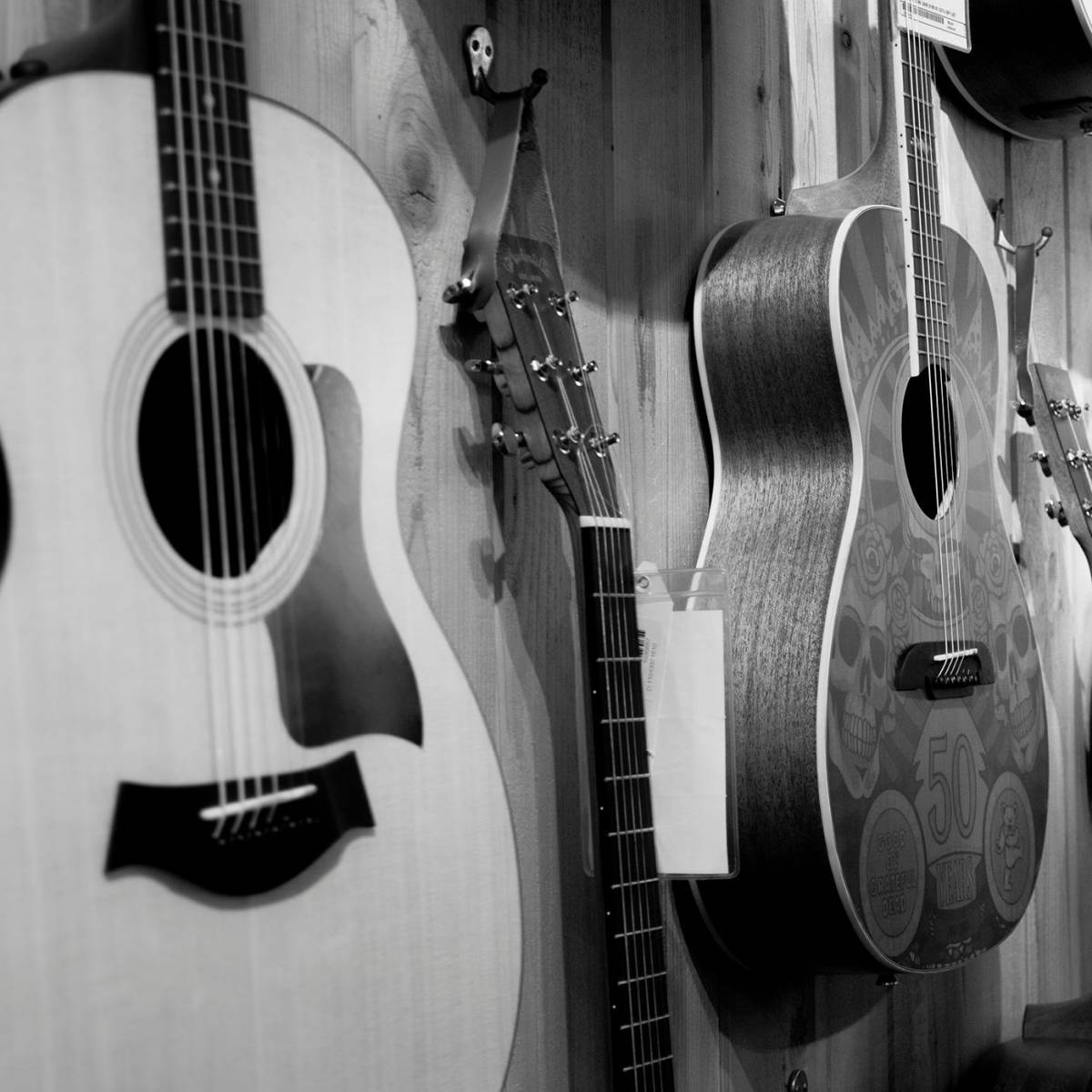 A line-up of steel string guitars on the wall