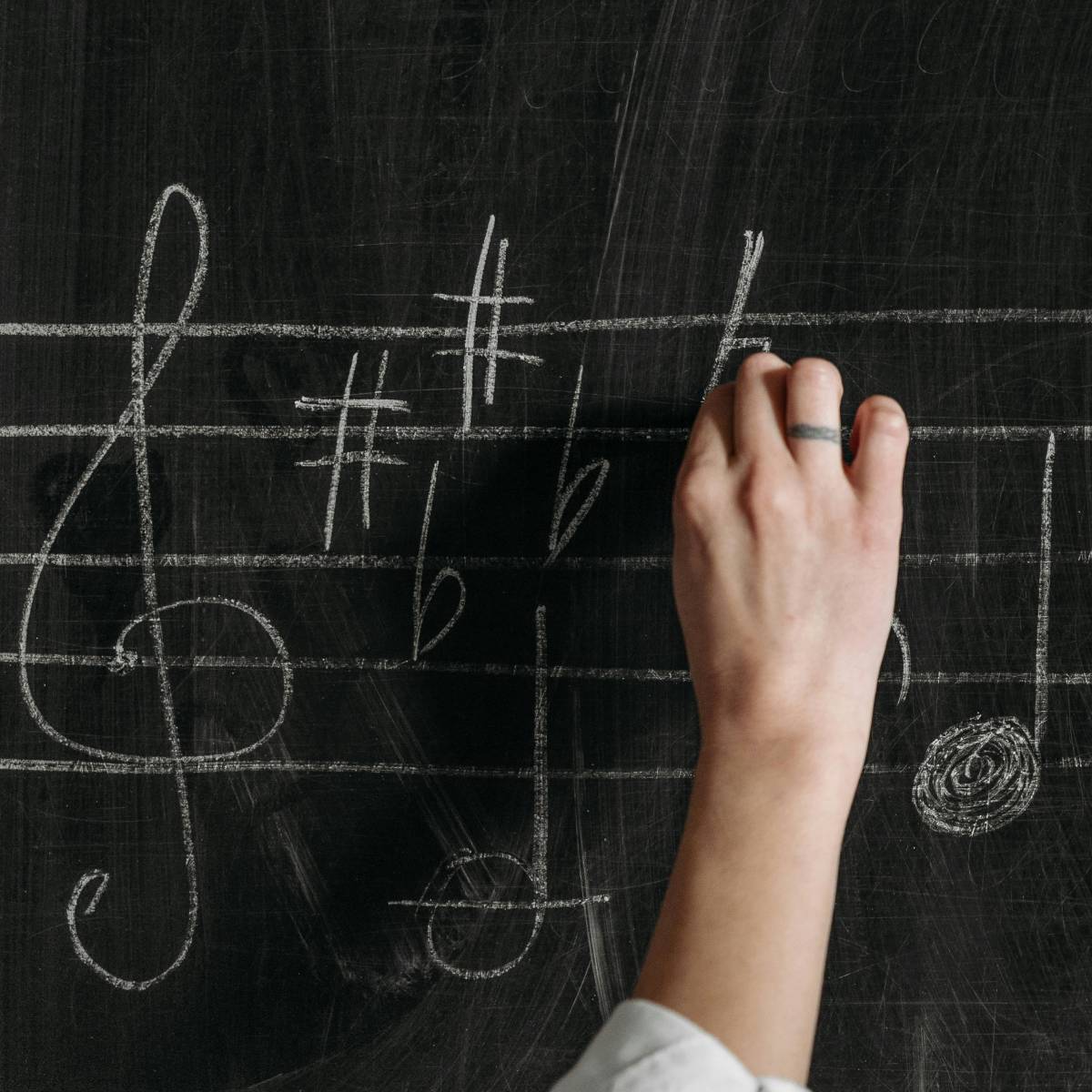 Hand writing music on a chalkboard