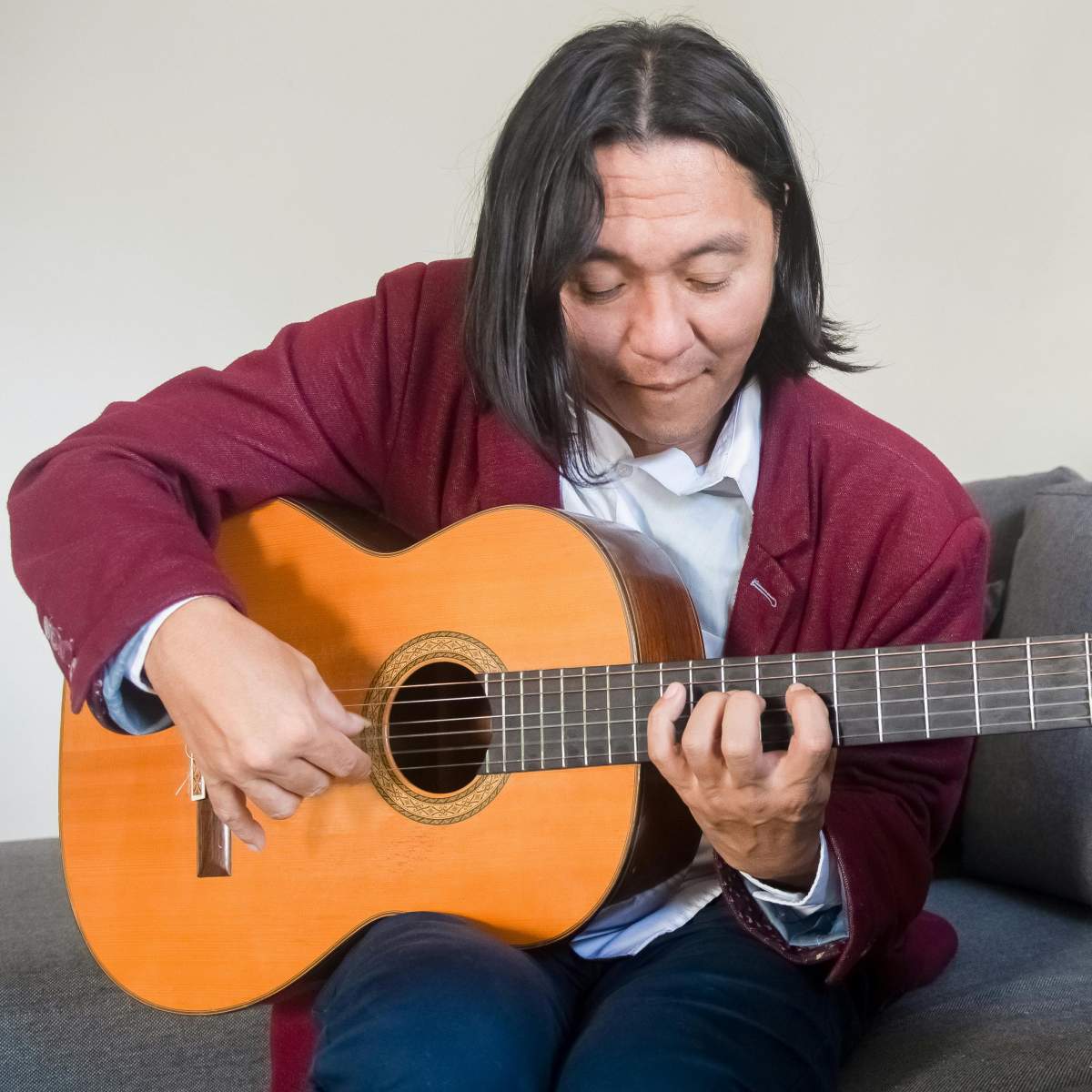 An expert guitarist playing a mean fingerstyle guitar