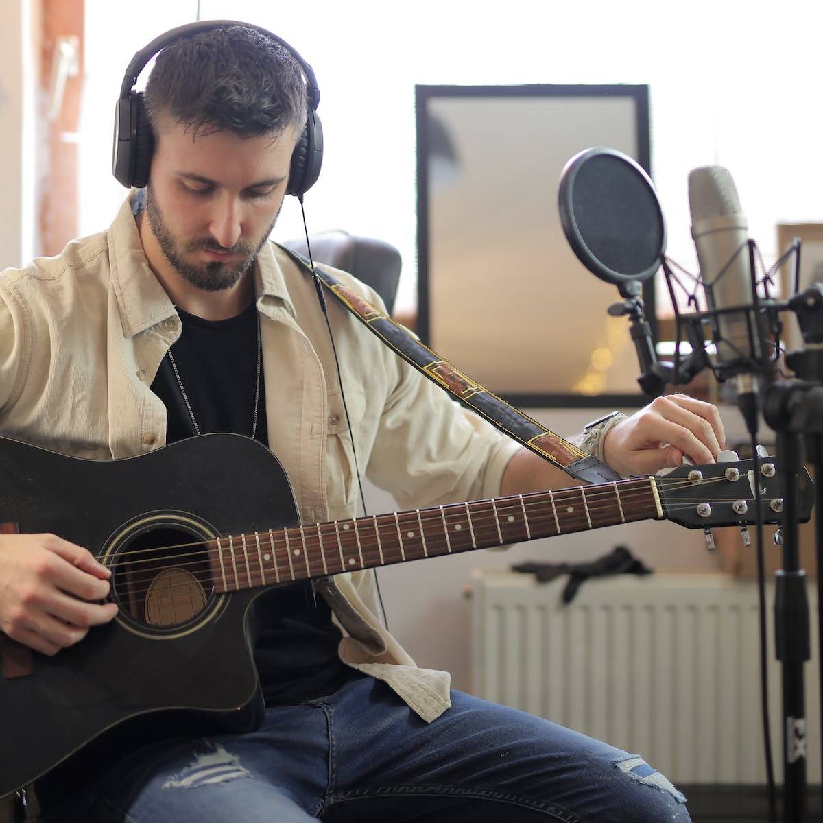 Tuning the sixth string of the acoustic guitar to get into an alternate tuning