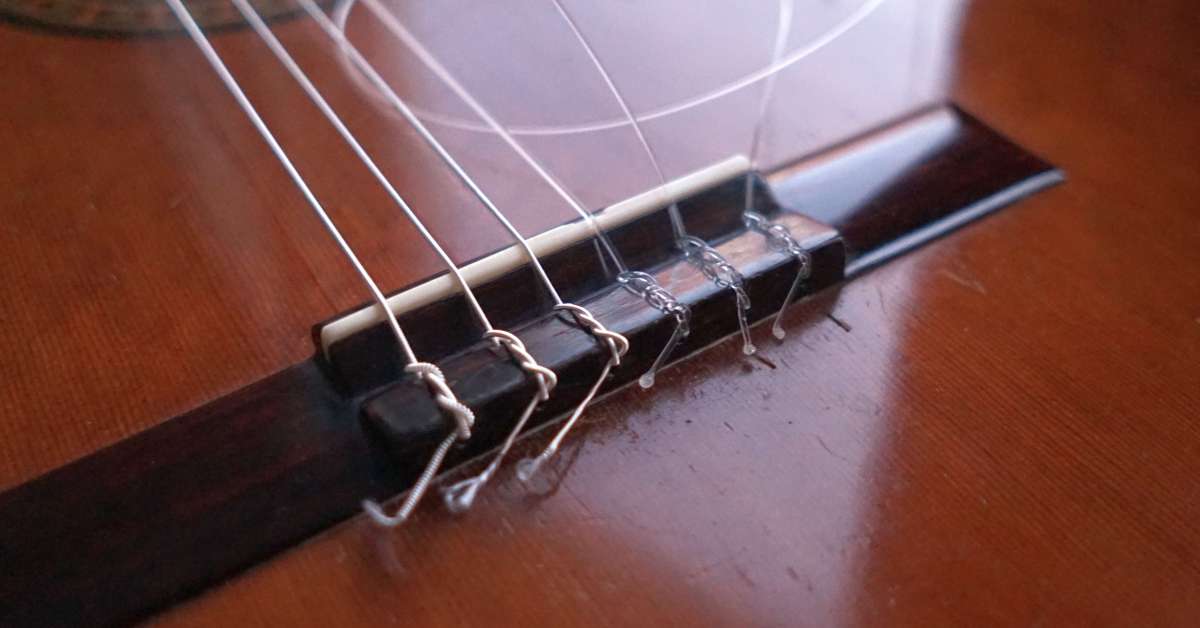 A set of Curt Mangan Normal Tension Nylon Strings tied to the bridge of the guitar